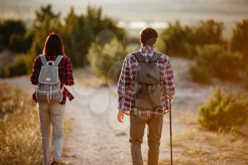 Portrait of happy young couple having fun on their hiking trip. Caucasian and asian hiker couple enjoying themselves on summer vacation. Young people hiking in nature.