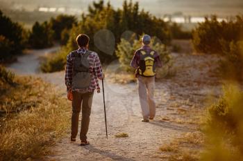 two men hikers enjoy a walk in nature, sunset time in summer. enjoying their adventure. Lifestyle hiking concept vacations outdoor