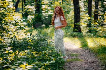 ginger charming woman young beautiful forest green. Caucasian girl relaxing and enjoying life on nature outdoors.
