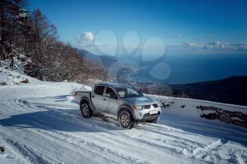 Pickup truck on road, Beautiful winter road under snow mountains. Shiny silver truck measuring the depth of the snow. idea and concept of freedom of movement in any weather