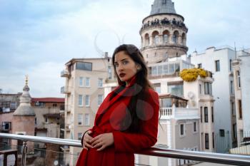 woman standing at the roof cafe with Istanbul on background, view of Galata tower in Beyoglu, Turkey. Travel and vacation in Turkey concept