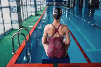Happy muscular swimming woman wearing glasses and cap at swim pool and represent health and fit concept, idea of sport, healthy lifestyle and leisure. girl meditates and regains strength after a swim