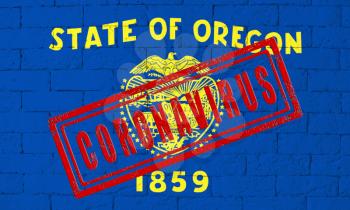 Flag of the State of Oregon painted on grungy brick wall background. with stamp CORONAVIRUS, idea and concept of healthcare, epidemic and disease in USA