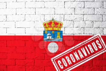 Flag of the regions or communities of Spain Cantabria with original proportions. stamped of Coronavirus. brick wall texture. Corona virus concept. On the verge of a COVID-19 or 2019-nCoV Pandemic