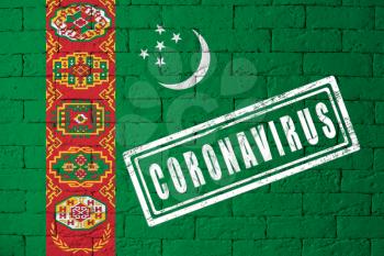 Flag of the Turkmenia with original proportions. stamped of Coronavirus. brick wall texture. Corona virus concept. On the verge of a COVID-19 or 2019-nCoV Pandemic.