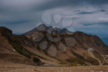 Autumn in the North Caucasus, Rosa Khutor ski resort in off-season. Russia, Sochi. Vintage toning. Travel background. Dramatic sky, sunset time, beautiful heavy clouds.