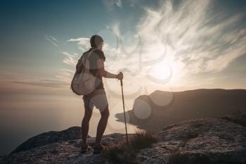 Man hiking at sunset mountains with heavy backpack. Travel Lifestyle wanderlust adventure concept summer vacations outdoor alone into the wild