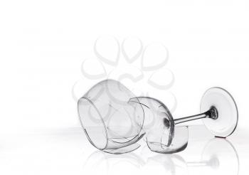 broken wine glass on a quilted table isolated on white background.