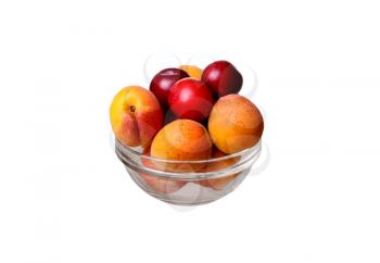 glass bowl with apricots and plums on a white background