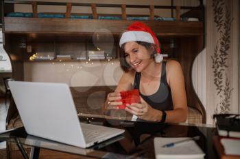 Christmas online congratulations. Smiling woman using pc computer for video call friends and parents. celebrating christmas online during coronavirus outbreak