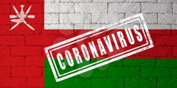 Flag of the Oman with original proportions. stamped of Coronavirus. brick wall texture. Corona virus concept. On the verge of a COVID-19 or 2019-nCoV Pandemic.