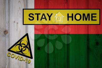 Flag of the Madagascar in original proportions. Quarantine and isolation - Stay at home. flag with biohazard symbol and inscription COVID-19.