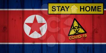 Flag of the North Korea in original proportions. Quarantine and isolation - Stay at home. flag with biohazard symbol and inscription COVID-19.