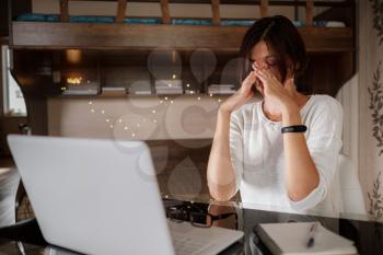 Upset asian woman working from home office. Unhappy freelancer using laptop and the Internet. Workplace in cozy bedroom. Concept of business and stress in epidemic crisis, social distancing