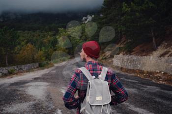 Man traveling with a backpack hiking in the mountains travel. Lifestyle success concept adventure, outdoor activities , plaid shirt hipster clothing