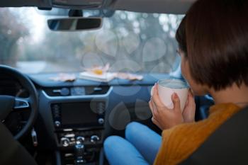 woman Drink coffee on the road. An autumn ride. The concept of freedom of movement. Autumn weekend.