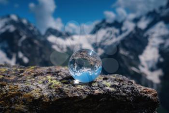 beautiful spherical glass ball with majestic Caucasian mountains, Dombai, Russia. the idea and concept of discovery, travel and trekking, Hiking theme.