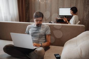Couple Working And Playing With Laptop Computer At Home.
