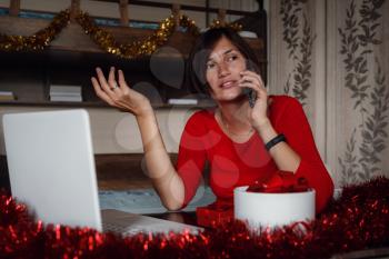 Photo of positive asian lady sit in bedroom and call by cellphone with christmas x-mas ornament. x-mas, winter holidays and people concept in covid time