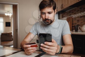hipster young man shopping online with credit card using smart phone at home. Indoor. online shopping concept.