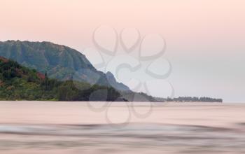 Bay at Hanalei in Kauai with the Na Pali mountain range in the background. Taken just after dawn with the rising sun lighting the peaks of the mountains at Hanalei, Kauai, Hawaii