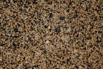 Macro view of the pebbles and stones on sandy beach in abstract background pattern