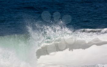 Frozen motion of large wave or breaker approaching shore and short shutter speed freezing the water into droplets
