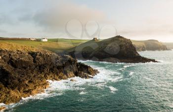 Doyden Castle on headland and whitewashed house on wide panorama of coastline at Port Quin, Cornwall, England, United Kingdom