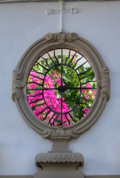 Secret flower garden glimpsed behind a carved opening or window in house wall in old city of Cordoba, Spain, Europe