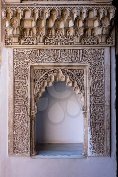 Wall mounted niche with ornate carved arch in courtyard of Alhambra palace Granada, Spain