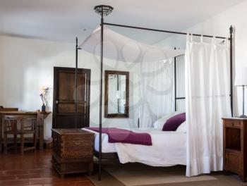 Four poster bed in rustic country hotel room in Spain