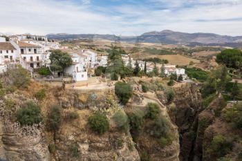 Old town buildings cling to rock face over El Tajo gorge at Ronda, Andalucia, Spain