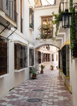 Narrow street with white homes and window grilles in Marbella, Andalucia, Spain