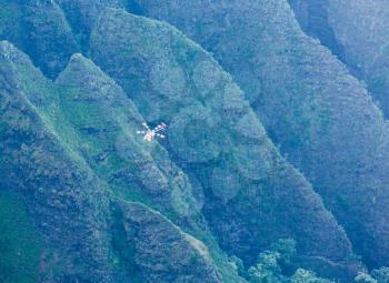 Helicopter on flight over Na Pali coast taken from end of Awa`awapuhi trail at Nualolo Valley overlooking Pacific ocean in Kauai, Hawaii, USA