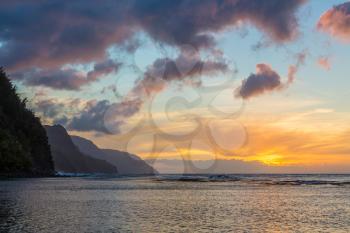 Sun setting over the receding headlands of the Na Pali coast from Ke'e Beach on north of Kauai, Hawaii