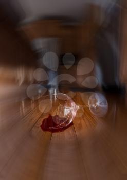 Concept of domestic disturbance at home with broken wine glass on floor of modern kitchen
