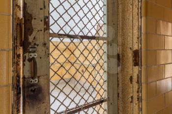 Metal barred door leading to cell inside Trans-Allegheny Lunatic Asylum in Weston, West Virginia, USA