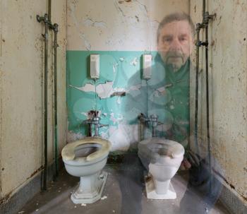 Ghostly senior man sitting on toilet inside Trans-Allegheny Lunatic Asylum in Weston, West Virginia, USA