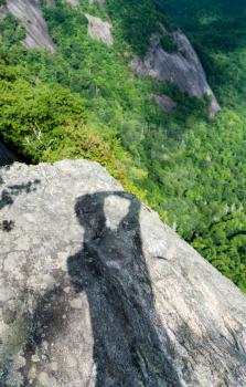 Shadow of photographer on Fools Rock at the summit of Whiteside Mountain near Highlands and Cashiers in North Carolina