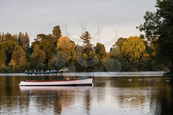 Old wooden pleasure boat moored on the mere at Ellesmere Shropshire in England at sunset