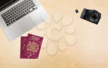 Photographers organized desk with laptop camera, memory cards and UK passports