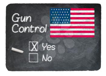 Gun Control voting choice message written on a chalky natural slate blackboard with yes  checkbox filled and chalk