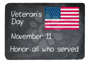Veteran's Day November 11 written in chalk on a chalky natural slate blackboard isolated against white background