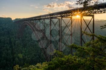 Setting sun behind the girders of the high arched New River Gorge bridge in West Virginia