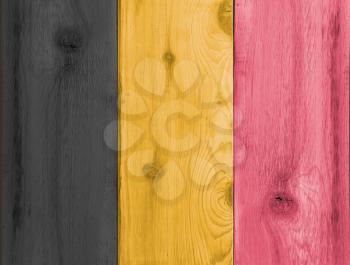 Timber planks of wood that have been painted or stained in the colors of a Belgium flag as a background