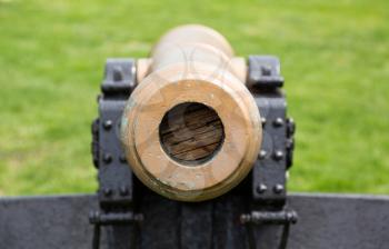 Detail of the muzzle of a painted military cannon pointing straight at the viewer who is in the sights for the shot