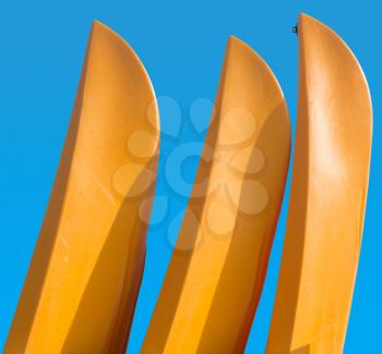 Three yellow prows of canoes or kayak with clipping path to allow easy isolation from blue sky behind the boats