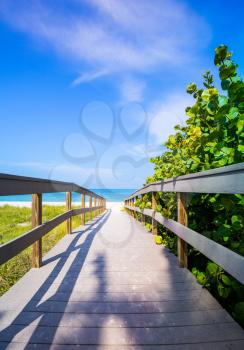 Wooden boardwalk to ocean amond sea oats on Sunset Beach at southern tip of Treasure Island Florida on Gulf of Mexico