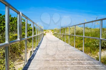 Wooden boardwalk to ocean amond sea oats on Madiera Beach north of Treasure Island Florida on Gulf of Mexico