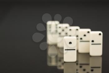 Number One domino in front of peers as concept image for success, innovation, leadership, winning and leader of the pack